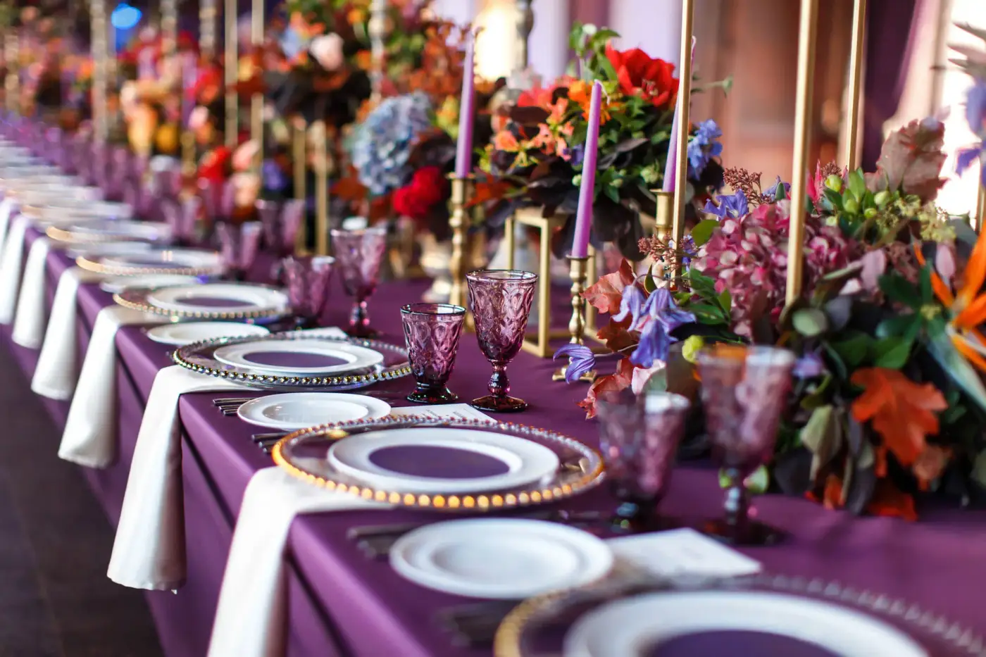 Festlich eingedeckte lange Tafel mit Blumenschmuck und Kerzen